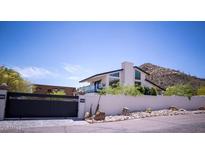 Modern home boasts a unique architectural design with desert landscaping and mountain views at 5801 E Surrey Dr, Cave Creek, AZ 85331