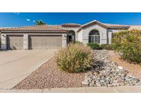 Charming single-story home with well-maintained landscaping and a three-car garage at 7130 E Laguna Azul Ave, Mesa, AZ 85209