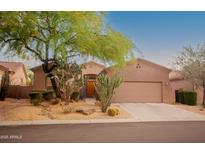 Charming single-story home featuring desert landscaping and a two-car garage, creating curb appeal at 7413 E Russet Sky Dr, Scottsdale, AZ 85266