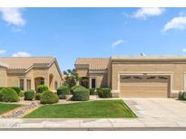 Beige single-story home featuring a manicured lawn and desert landscaping at 8426 W Utopia Rd, Peoria, AZ 85382