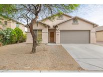 Charming single-story home featuring a two-car garage and a low maintenance desert landscape at 11702 W Lincoln St, Avondale, AZ 85323