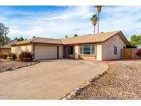 Charming single-story home featuring a well-maintained front yard and attached two-car garage at 1409 S Revere --, Mesa, AZ 85210