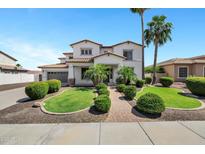 Beautiful two-story home with lush landscaping, a brick walkway, and a three car garage at 18429 W Mauna Loa Ln, Surprise, AZ 85388