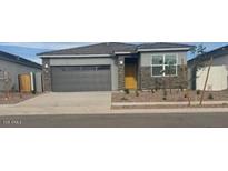 Charming single-story home featuring a gray exterior, gray garage door, and low maintenance landscaping at 25235 N 183Rd Dr, Wittmann, AZ 85361