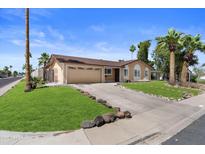 Charming home with a two-car garage, green lawn, desert landscaping, and inviting curb appeal at 3636 W Crocus Dr, Phoenix, AZ 85053