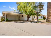 Charming single-story home featuring a large carport, basketball hoop, and lush landscaping at 7424 E Cambridge Ave, Scottsdale, AZ 85257