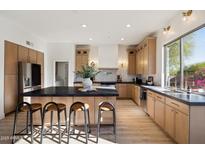Open kitchen with a large island, modern appliances, and hardwood floors at 9322 E Hidden Green Dr, Scottsdale, AZ 85262