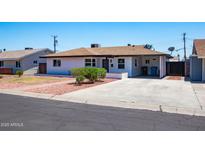 Charming single-story home with a spacious driveway, well-maintained lawn, and desert landscaping at 1011 W Weldon Ave, Phoenix, AZ 85013