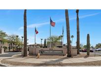Eagles Landing community entrance with desert landscaping, flags, and signage at 14815 N Fountain Hills Blvd # 101, Fountain Hills, AZ 85268