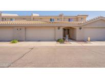 Charming townhouse featuring a beige facade, two-car garage, and tiled roof at 16021 N 30Th St # 122, Phoenix, AZ 85032