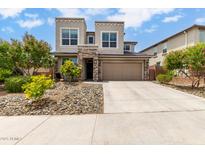 Beautiful two-story home featuring stone accents, a two-car garage, and rock landscaping at 16539 W Winston Dr, Goodyear, AZ 85338