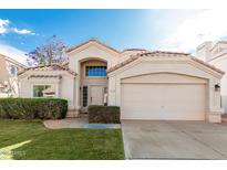 Inviting single-story home featuring a well-maintained front yard and a two-car garage at 2134 W Peninsula Cir, Chandler, AZ 85248