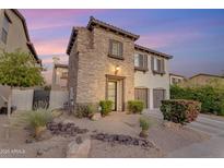 Charming two-story home with stone accents, two-car garage, and desert landscaping in the front yard at 22317 N 39Th Run, Phoenix, AZ 85050