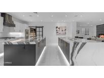 Gourmet kitchen with double islands, high-end appliances, custom hood, and an open layout for seamless entertaining at 22317 N 39Th Run, Phoenix, AZ 85050