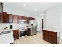 Well-lit kitchen with stainless steel appliances, dark wood cabinets and sleek countertops at 2402 E 5Th St # 1498, Tempe, AZ 85288
