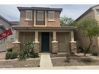 Charming two-story home with a welcoming front porch and stone accents, creating a warm and inviting curb appeal at 3009 S 101St Ln, Tolleson, AZ 85353
