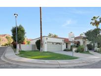 Charming single-story home boasts a red tile roof, lush landscaping, and a two-car garage at 3417 E Mission E Ln, Phoenix, AZ 85028