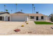 Charming single-story home with well-manicured desert landscaping and a two car garage at 5909 E Crocus Dr, Scottsdale, AZ 85254