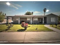 Charming single story home featuring mature landscaping, rose bushes and a covered front porch at 6111 N 64Th Dr, Glendale, AZ 85301