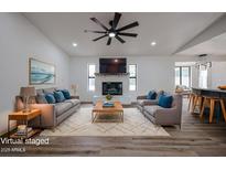 Bright living room with brick fireplace, ceiling fan, and modern furnishings at 619 N Norfolk --, Mesa, AZ 85205