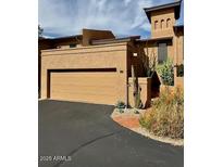 Desert home with a tan stucco exterior, a two car garage and drought-resistant landscaping at 7432 E Hum Rd # 203, Carefree, AZ 85377