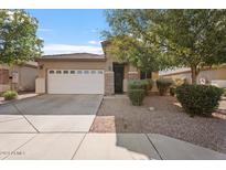 Charming single-story home with a well-manicured front yard and a two-car garage at 7818 S 74Th Ave, Laveen, AZ 85339