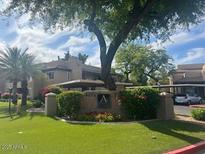 Charming condo complex with lush landscaping and mature shade trees on a partly cloudy day at 9450 E Becker Ln # 2051, Scottsdale, AZ 85260