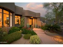 Inviting front entrance with desert landscaping, warm lighting, and a charming southwestern architectural design at 10040 E Happy Valley Rd # 1011, Scottsdale, AZ 85255