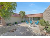 Inviting courtyard featuring a charming water fountain and a small sitting area with blue Adirondack chairs at 13806 N Del Webb Blvd, Sun City, AZ 85351