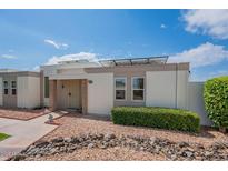 Charming single-story home featuring desert landscaping, and modern solar panels on the roof at 14080 N Newcastle Dr, Sun City, AZ 85351
