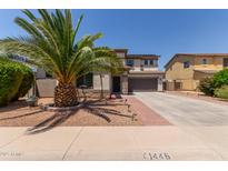 Two-story home with desert landscaping, brick accents, and a large palm tree in the front yard at 1446 E Douglas St, Casa Grande, AZ 85122