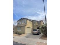 Tan two-story home featuring a two-car garage and a modern driveway at 17335 W Woodlands Ave, Goodyear, AZ 85338