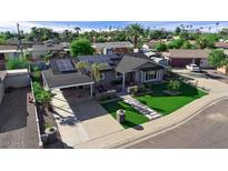 Charming home featuring a covered carport, desert landscaping, and solar panels for energy efficiency at 2656 N 84Th Pl, Scottsdale, AZ 85257
