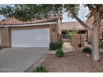 Charming home featuring a white garage door, terra cotta tile roof, and tasteful landscaping at 3510 E Hampton Ave # 74, Mesa, AZ 85204