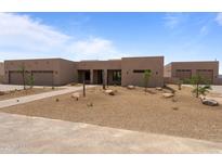 A stunning, desert-landscaped single-story home features a clean modern aesthetic and three-car garage at 39302 N 30Th Dr, Phoenix, AZ 85086