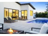 Modern backyard featuring a pool, lounge chairs, and a fire pit with views into the home at 4002 N 33Rd Pl, Phoenix, AZ 85018