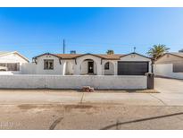 Charming single-story home featuring a stylish black garage door and an eye-catching arched entryway at 4611 N 79Th Dr, Phoenix, AZ 85033