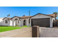 Charming single-story home boasts a manicured lawn, arched entry, and contrasting trim, offering curb appeal at 4611 N 79Th Dr, Phoenix, AZ 85033