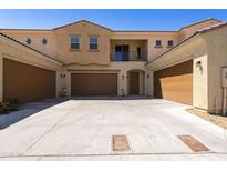 Beige two-story home with brown garages, balcony, and a spacious concrete driveway at 1367 S Country Club Dr # 1167, Mesa, AZ 85210