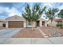 Charming single-story home featuring a two-car garage and desert landscaping in front at 14752 W Evans Dr, Surprise, AZ 85379