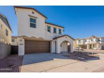 Charming two-story home featuring a brown two-car garage door, arched entrance, and well-maintained landscaping at 2195 N Peden Dr, Chandler, AZ 85225