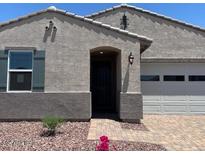 Charming single story home featuring a low maintenance rock yard, attached two car garage, and covered entryway at 24486 W Grenadine Rd, Buckeye, AZ 85326