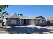 Charming single-story home featuring a well-maintained front yard and attached garage with a curved driveway at 2908 N 53Rd Ln, Phoenix, AZ 85031