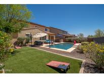 Inviting backyard with lush artificial turf, swimming pool, and comfortable lounge area at 31046 N 138Th Ave, Peoria, AZ 85383