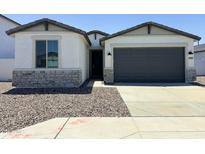 Charming single-Gathering home featuring stone accents, a two-car garage, and a well-maintained gravel yard at 5019 W Walatowa St, Laveen, AZ 85339