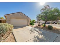 Well-maintained one-story home with a long driveway, two-car garage and tidy desert landscaping at 8104 S 73Rd Dr, Laveen, AZ 85339