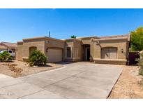 Single-story home with a two-car garage, desert landscaping and a concrete driveway at 870 E Megan St, Gilbert, AZ 85295