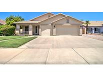 Charming single-story home featuring a two-car garage and well-manicured front yard at 14298 W Amelia Ave, Goodyear, AZ 85395