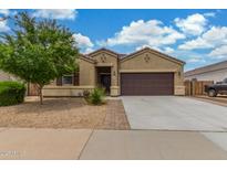 Charming single-story home with a two-car garage, neutral stucco, and low-maintenance desert landscaping at 16938 N Verde Pl, Maricopa, AZ 85138