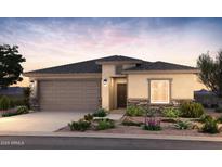 Charming single-story home featuring a two-car garage, stone accents, and desert landscaping at 17746 W Getty Dr, Goodyear, AZ 85338